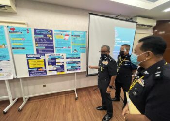 RAMLI MOHAMED YOOSUF (kiri) menunjukkan antara kaedah penipuan yang dilakukan suspek terhadap mangsa jenayah komersial di IPK Pahang di Kuantan, Pahang.