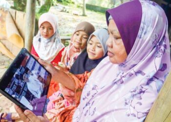 GOLONGAN M40, Hasnah Chik, 68, bersama cucunya mengikuti pembentangan Belanjawan 2023 yang disampaikan oleh Perdana Menteri, Datuk Seri Anwar Ibrahim di Kampung Cemperai, Dengkil, semalam. - UTUSAN/FAISOL MUSTAFA