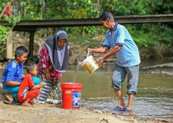 MOHD. Nopiah Jarit (kanan) dan kakaknya, Remiah Jarit menimba air sungai untuk kegunaan keluarga selain menggunakan sumber air bukit berdekatan 
di Kampung Tanjung Pari, Baling. Selain itu, penduduk yang terjejas juga bergantung kepada air perigi. – UTUSAN/SHAHIR NOORDIN