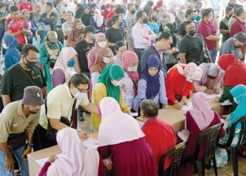 Ibu bapa hadir mengambil bantuan awal persekolahan di Sekolah Kebangsaan Bandar  Tun Hussein Onn 2 di Cheras semalam. – UTUSAN/FAUZI BAHARUDIN