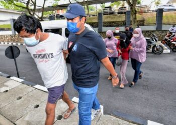 KHALID Redza Shuib (kiri) bersama anak perempuannya (berbaju merah) yang berusia 18 tahun ketika didakwa di Mahkamah Majistret Seremban pada 13 April lalu.- UTUSAN/MOHD. SHAHJEHAN MAAMIN.