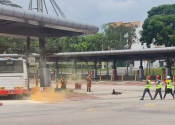Anggota ERT dari Larkin Sentral melakukan semburan ke atas sebuah bas dalam sesi latihan kebakaran di Larkin Sentral Johor Bahru, hari ini. -UTUSAN/RAJA JAAFAR ALI