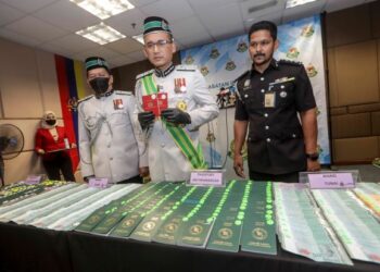 KHAIRUL Dzaimee Daud menunjukkan pasport yang dirampas dalam sidang akhbar berkenaan Sindiket Agensi Pekerjaan Haram di Jabatan Imigresen, Putrajaya. -UTUSAN/FAISOL MUSTAFA