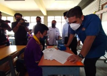 RADZI Jidin beramah mesra dengan seorang calon SPM semasa melawat SMKA Lati, Pasir Mas, Kelantan, semalam. – UTUSAN/YATIMIN ABDULLAH