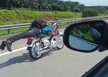 TANGKAP layar daripada video menunjukkan seorang penunggang motosikal yang melakukan aksi Superman sebelum ditahan di LPT I, Kemaman, Terengganu, semalam. - MEDIA SOSIAL