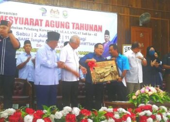 AHMAD Hamzah (kanan) menyampaikan cenderamatai kepada bekas Pengurus Besar PPK Kuala Langat, Shakran Shamsuddin dalam Majlis Perasmian Mesyuarat Agung Tahunan PPK Kuala Langat, Selangor, hari ini. - UTUSAN / ABDUL RAZAK IDRIS