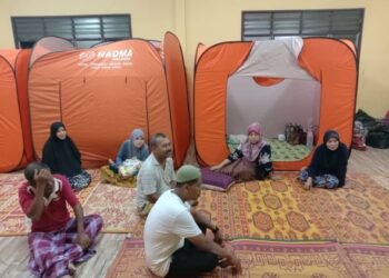 Syed Abu Bakar Syed Mat Nor (baju putih) menyantuni penduduk yang berada di PPS SK Tok Deh, Rantau Panjang, Kelantan hari ini.