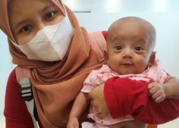Nurul Hasya Adzkiya dipangku ibunya,, Nurul Ain Halimatussaadiah ketika datang ke pejabat One Hope Charity di Bukit Mertajam, baru-baru ini