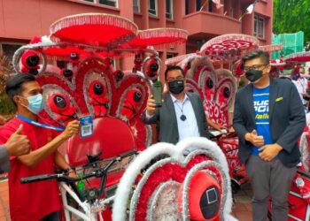 SULAIMAN Md. Ali menunjukkan pembayaran menggunakan Touch 'n Go eWallet ketika penyampaian sumbangan Aidilfitri kepada pengayuh beca di Muzium Rakyat, Banda Hilir, Melaka. - UTUSAN/DIYANATUL ATIQAH ZAKARYA