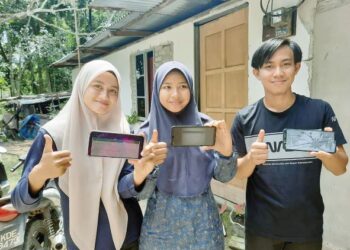 OMAR Mokhtar Abd. Rahman, Salmah Aminudin (tengah) dan Norasyikin Azizan menunjukkan surat tawaran melalui telefon pintar bagi melanjutkan pengajian ke universiti tempatan di Pokok Sena, Kedah, semalam. -UTUSAN/ MOHD RIFAAT ABD HAMID