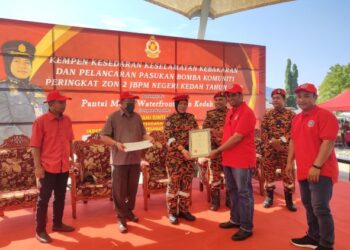SAYANI Saidon menyampaikan sijil kepada wakil pasukan Bomba Komuniti Zon II sempena Kempen Kesedaran Keselamatan Kebakaran di Pantai Murni, Yan. -UTUSAN/NUR SYAZWANA MANSOR