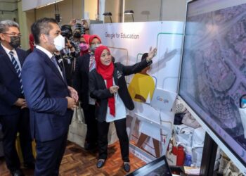 RADZI Jidin mendengar penerangan semasa melawat ruang pameran selepas Majlis Pelancaran DELIMa: Agenda Digital Kita di SMK Putrajaya Presint 8 (1). - UTUSAN/FAISOL MUSTAFA
