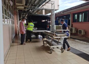 AZMAN Mahmood (kiri) mengiringi jenazah anaknya di Unit Forensik HUSM Kubang Kerian, Kelantan. – Utusan/ROSALWANI CHE SOH