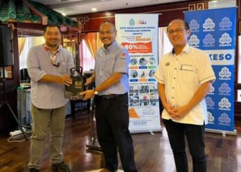 ABD. RAZAK Omar (tengah) menyampaikan cenderamata kepada salah seorang penerima caruman sambil disaksikan Ngwe Hee Sem dalam Majlis Perkeso Mendekati Media di sebuah hotel di Jalan Bendahara, Melaka. - UTUSAN/AMRAN MULUP