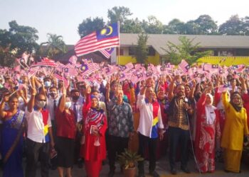 Mohd. Azhar Zamri  (depan lapan dari kiri) dan Aisah (depan, sembilan dari kiri) melaungkan ungkapan merdeka sambil mengibarkan Jalur Gemilang pada program sambutan bulan kebangsaan di SMK Kampung Jawa, baru-baru ini. - UTUSAN/ABDUL RAZAK IDRIS