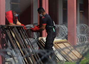 ANGGOTA pasukan keselamatan memasang pagar kawat duri di kuaters wadar dan bangunan penjara Seremban, semalam ekoran pelaksanaan Perintah Kawalan Pergerakan Diperketatkan (PKPD) sehingga 7 Disember ini. – UTUSAN/MUHAMMAD IZZAT TERMIZIE
