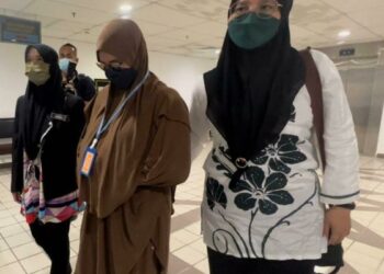 EZZA Suria Muda (tengah) yang dituduh memalsukan borang pendaftaran pekerja PenjanaKerjaya dibawa di Mahkamah Sesyen Kuala Terengganu, hari ini. - UTUSAN/KAMALIZA KAMARUDDIN