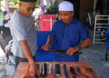 Mior Azizan Abdul Talib (kiri)  menunjukkan koleksi pisau menyembelih kepada seorang ahli kariah di Kampung Perepat, Klang.
ABDUL RAZAK IDRIS