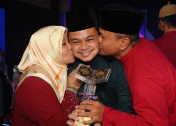 Aiman Ridhwan Mohamad Ramlan diberi ciuman tahniah oleh ibunya, Umi Kalsum Sukri dan bapanya, Mohamad Ramlan selepas muncul johan Majlis Tilawah dan Hafazan al-Quran Peringkat Kebangsaan 2022 di Pusat Islam Iskandar Johor Bahru, malam tadi. -UTUSAN/RAJA JAAFR ALI