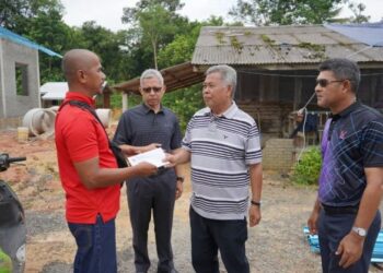 AHMAD Said (dua dari kanan kanan) menyampaikan bantuan kepada salah seorang penduduk yang terlibat dalam kejadian ribut di Bandar Baru Cheneh, Kemaman, semalam. - UTUSAN/NIK NUR IZZATUL HAZWANI NIK ADNAN