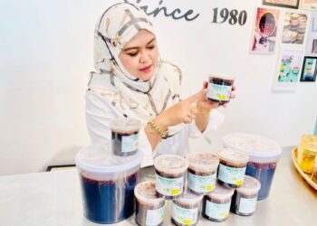 SHAZANA Mahazir menunjukkan logo pada bekas Kuah Rojak Mak Bee yang asli di Mak Bee Mart, Alor Setar, Kedah hari ini. - UTUSAN/JAMLIAH ABDULLAH