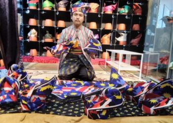ABDUL Hakim Ismail menunjukkan tanjak bermotifkan Jalur Gemilang yang sudah siap dihasilkan di Pengkalan Chepa, Kota Bharu, Kelantan semalam. – UTUSAN/ROHANA MOHD.NAWI