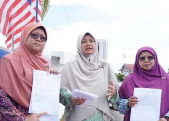 ZURAIDA Md. Noor (tengah) menunjukkan salinan laporan polis yang dibuat penganjur HSA di IPK, Kuala Terengganu, semalam.