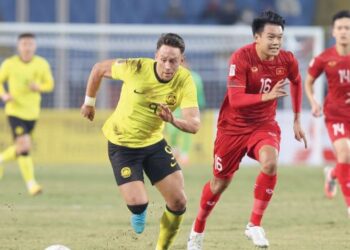 PENYERANG Malaysia, Darren Lok (kiri) bersaing dengan pertahanan Vietnam, Nguyen Thanh Chung  dalam saingan Kumpulan B, Piala AFF 2022 di Stadium My Dinh, Hanoi kelmarin. Malaysia tumpas 3-0, dan kedua-dua pasukan menutup perlawanan dengan 10 pemain.