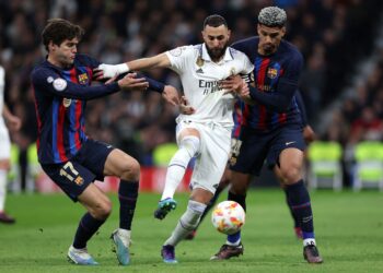 PENYERANG Real Madrid, Karim Benzema (tengah) dicabar dua pemain Barca Marcos Alonso (kiri) dan Ronald Araujo pada separuh akhir pertama Piala Raja Sepanyol, awal pagi tadi.-AFP