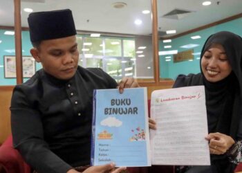 SHAHROL Harun (kiri) dan Siti Farah Marzuki menunjukkan buku Bijak Menulis Abjad Berekor (Binujar) yang membantu mengatasi masalah menulis mekanis murid iaitu kekemasan menulis menggunakan tangan,  hari ini.

GAMBAR : FAISOL MUSTAFA