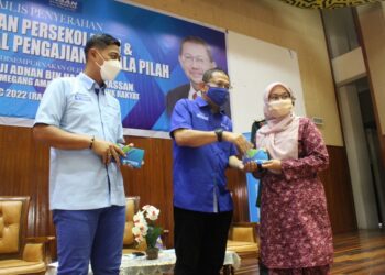 ADNAN Abu Hassan (enyampaikan bantuan wang tunai kepada seorang pelajar sambil diperhatikan oleh Mohd. Shahrizal dalam Majlis Penyerahan Bantuan Awal Pengajian dan Bantuan Persekolahan YBR di Kompleks Rakan Muda, Jalan Melang, Kuala Pilah hari ini