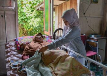 ADIK Allahyarham Siti Nor Surya, Nur Liyana Syuhada Ismail menjaga ibunya yang terlantar sakit di Kampung Lubuk Batu, Kuala Telemong, Hulu Terengganu, semalam. – UTUSAN/PUQTRA HAIRRY