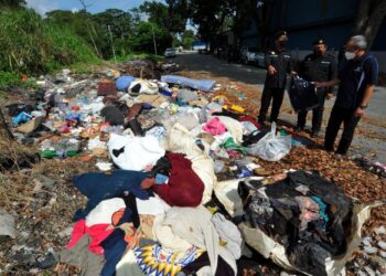 CAIRUL Hisham Jalaluddin (kiri) melihat pembuangan sampah haram di Taman Mount Austin, Johor Bahru. - FOTO/RAJA JAAFAR ALI
