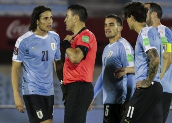 PENGADIL, Roberto Tobar melayangkan kad merah kepada Edinson Cavani (kiri) dalam aksi kelayakan Piala Dunia 2022 zon Amerika Selatan di Stadium Centenario, Montevideo  hari ini. - AFP
