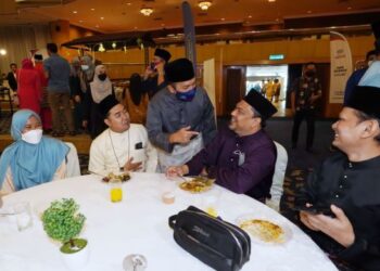KHAIRIL Anuar Mohammad Anuar (berbaju kelabu berdiri) beramah mesra bersama tetamu pada Rumah Terbuka Aidilfitri Co-op Bank Pertama.