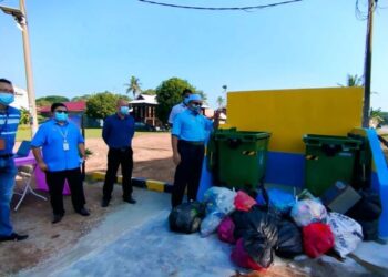 ROZALI Mohamud (kanan) menunjukkan sisa pepejal yang dibuang di luar tong hingga mengotorkan kawasan sekitar di Jalan Bagan Selat, Telok Air Tawar, Butterworth, Pulau Pinang.