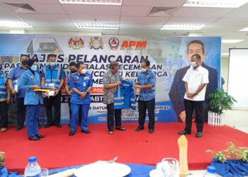 ABD. Latiff Ahmad (tiga dari kanan) menyerahkan jaket CDERT kepada penghulu mukim di Mersing ketika merasmikan Majlis Pelancaran CDERT Keluarga Malaysia Parlimen Mersing di Politeknik Mersing, Johor. -UTUSAN/MASTURAH SURADI