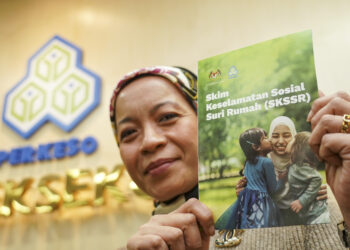 KAKITANGAN Pertubuhan Keselamatan Sosial (PERKESO) menunjukkan risalah Skim Keselamatan Sosial Suri Rumah (SKSSR) di Menara PERKESO, semalam. - UTUSAN/MUHAMAD IQBAL ROSLI