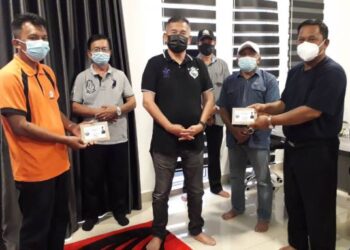 CHE Zakaria Mohd. Salleh (tengah) menyerahkan sumbangan kepada Ketua Kampung Felda Sungai Mas, Nizam Ali (kanan) di Kediaman Rasmi Pengerusi Kejora, Bandar Penawar, Kota Tinggi, Johor.