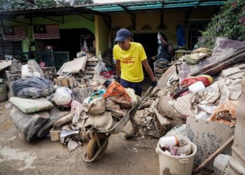 Seorang penduduk melakukan kerja-kerja pembersihan rumah yang dipenuhi selut akibat banjir lumpur di Taman Chegar Medang, Bentong pada 20 Disember 2021. -UTUSAN/MOHD FARIZWAN HASBULLAH
