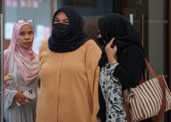 SITI Bainun Ahd. Razali (tengah) hadir bagi keputusan berhubung pertuduhan mengabai dan menganiaya remaja perempuan Sindrom Down yang dikenali sebagai Bella di Kompleks Mahkamah Kuala Lumpur di sini, hari ini. -UTUSAN/FARIZ RUSADIO