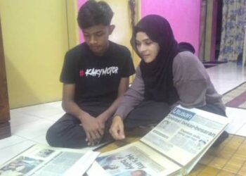 MOHAMMAD Nursyabil Syakirin Mohammad Nordin dan Norhayati Abu Bakar melihat keratan akhbar mengenai laporan kes culik membabitkan dirinya ketika berusia enam hari di Sungai Lalang, Sungai Petani, Kedah, kelmarin.