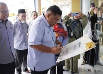 ZAINUDIN Mohamed (tengah) menandatangani plak ketika merasmikan premis Pajak Gadai Islam Ar-Rahn Cawangan kedua di Baling, Kedah, baru-baru ini. – FOTO/NORLIA RAMLI