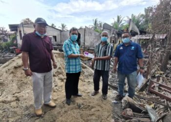 CHE Abdullah Mat Nawi (dua kiri) menyampaikan sumbangan kepada Mohd. Nawawi Che Soh yang ditimpa musibah selepas rumahnya terbakar di Kampung Besut, Tumpat, Kelantan hari ini. - YATIMIN ABDULLAH