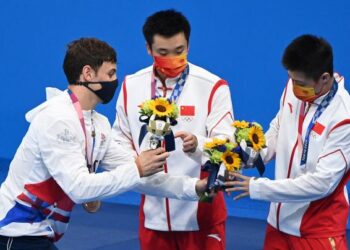 PEMENANG pingat gangsa dari Britain Thomas Daley (kiri) bersama pemenang emas dan perak Cao Yuan (tengah) dan Yang Jian (kanan) dari China berbual selepas menerima pingat dalam acara terjun 10 meter platform lelaki di Olimpik Tokyo 2020. - AFP