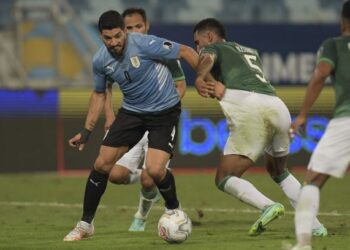 LUIS Suarez (kiri) cuba melepasi pemain pertahanan Bolivia, Adrian Jusino dalam kejohanan Copa America 2021 di Stadium Arena Pantanal, Cuiaba, Brazil, kelmarin. – AFP