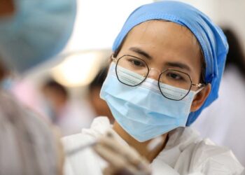 PETUGAS kesihatan memberi suntikan vaksin kepada penduduk di sebuah pusat vaksinasi di Rongan, wilayah Guangxi, selatan China. - AFP