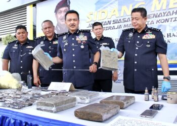 MOHD. Yusri Hassan Basri (tengah) menunjukkan dadah yang dirampas dalam serbuan pihak polis di Jelapang kelmarin dalam sidang akhbar di IPK Perak di Ipoh hari ini. - UTUSAN/MUHAMAD NAZREEN SYAH MUSTHAFA