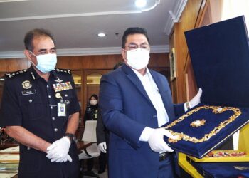 SULAIMAN Md. Ali (kanan) menunjukkan  pingat Darjah Kebesaran Negeri Melaka palsu sambil diperhatikan Abdul Majid Mohd. Ali di Seri Negeri, Ayer Keroh, Melaka. - UTUSAN/DIYANATUL ATIQAH ZAKARYA