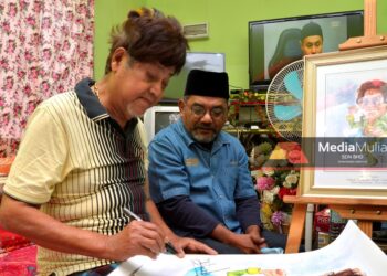 M. Daud Kilau menandatangani karikatur beliau sambil disaksikan oleh Mohd. Desa Omar atau Juragan di rumah penyanyi veteran itu di Bagan Datuk, Perak, semalam. – Utusan/ZULFACHRI ZULKIFLI